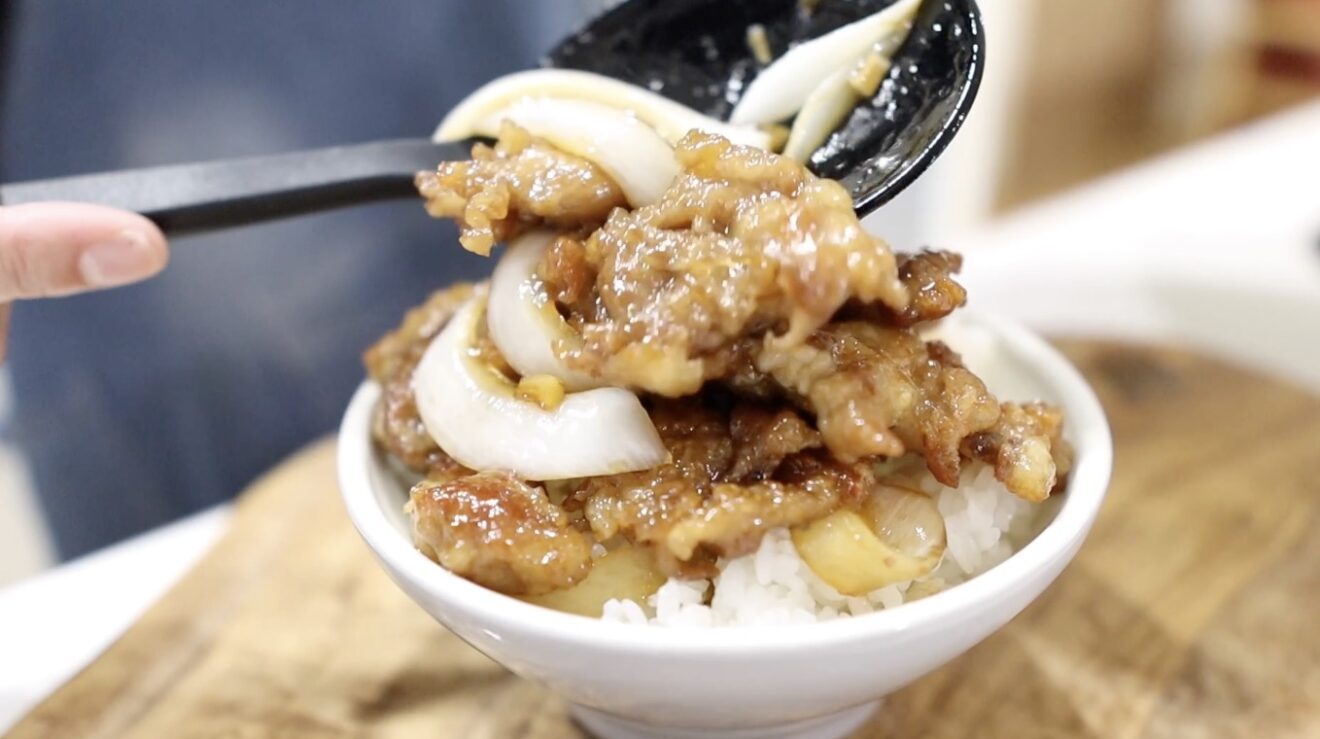 丼のご飯に豚こまと玉ねぎを盛り付ける
