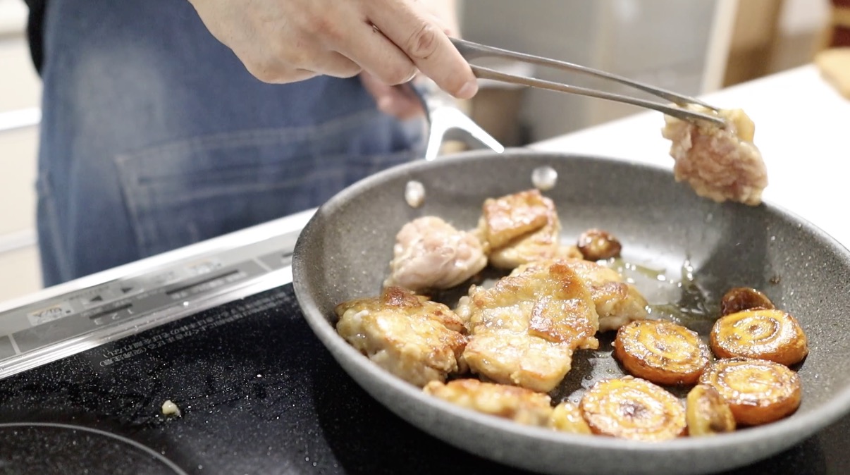 キツネ色になった鶏もも肉をひっくり返す